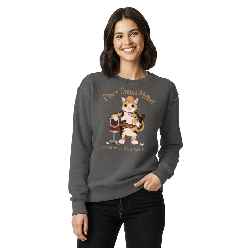 Model wearing a pepper charcoal grey garment-dyed sweatshirt with a calico cowboy cat and Don't Stress Meowt cat cafe lettering.