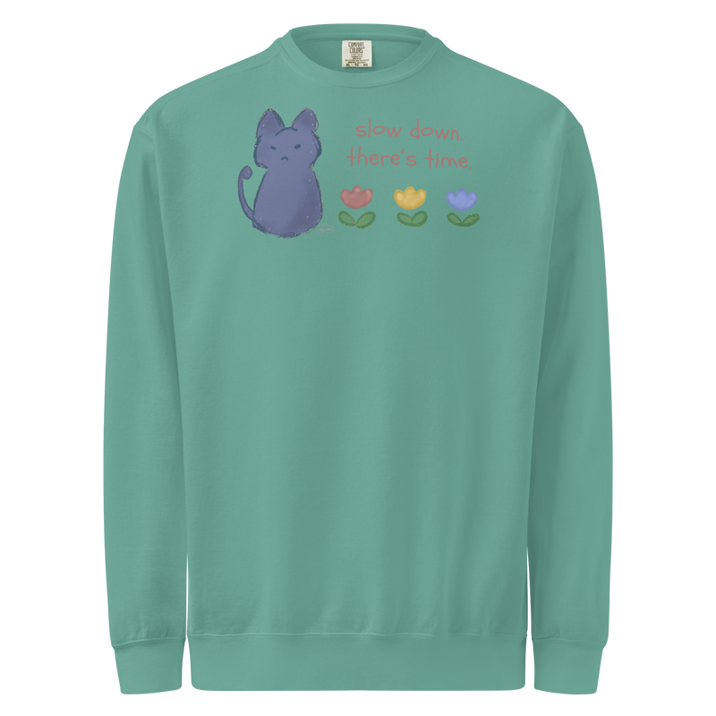 Seafoam green garment-dyed sweatshirt with a blue cat, three flowers, and 'Slow down, there's time' lettering.