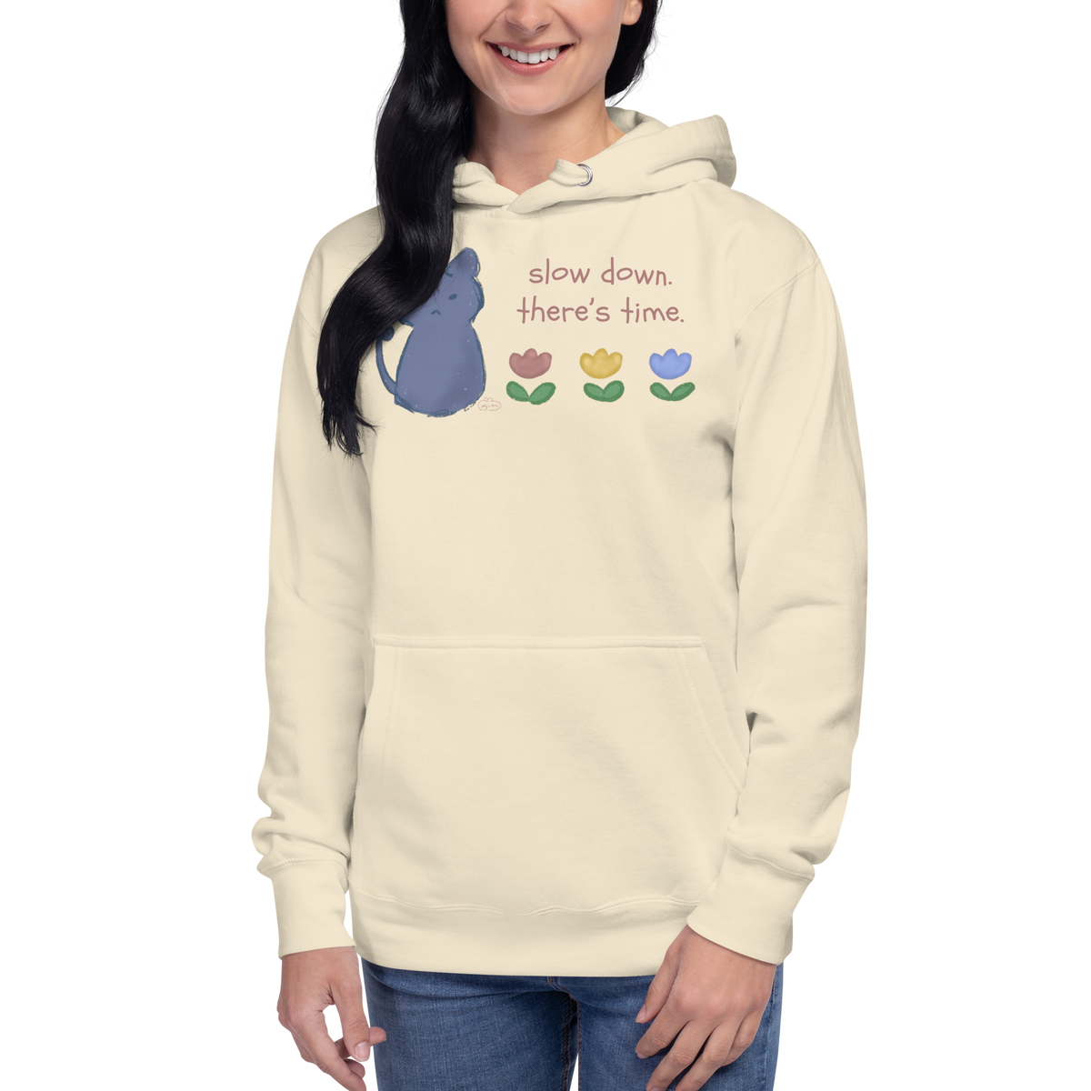 Model wearing a bone cream pullover hoodie with a blue cat, three flowers, and 'Slow down, there's time' lettering.