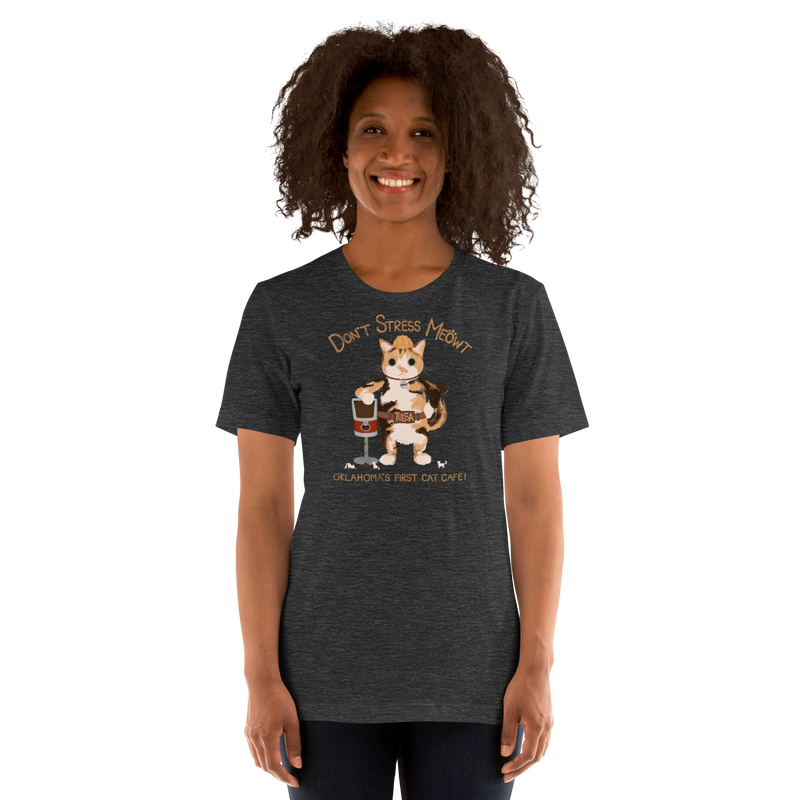 Model wearing a dark heather grey Bella + Canvas T-shirt with a calico cowboy cat and Don't Stress Meowt cat cafe lettering.