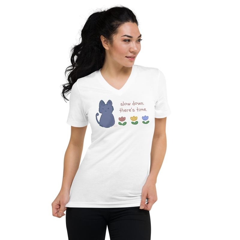 Model wearing a white V-neck T-shirt with a blue cat, three flowers, and 'Slow down, there's time' lettering.